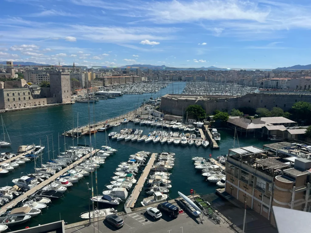 Vue aérienne du Vieux Port de Marseille avec de nombreux bateaux amarrés et le ciel bleu